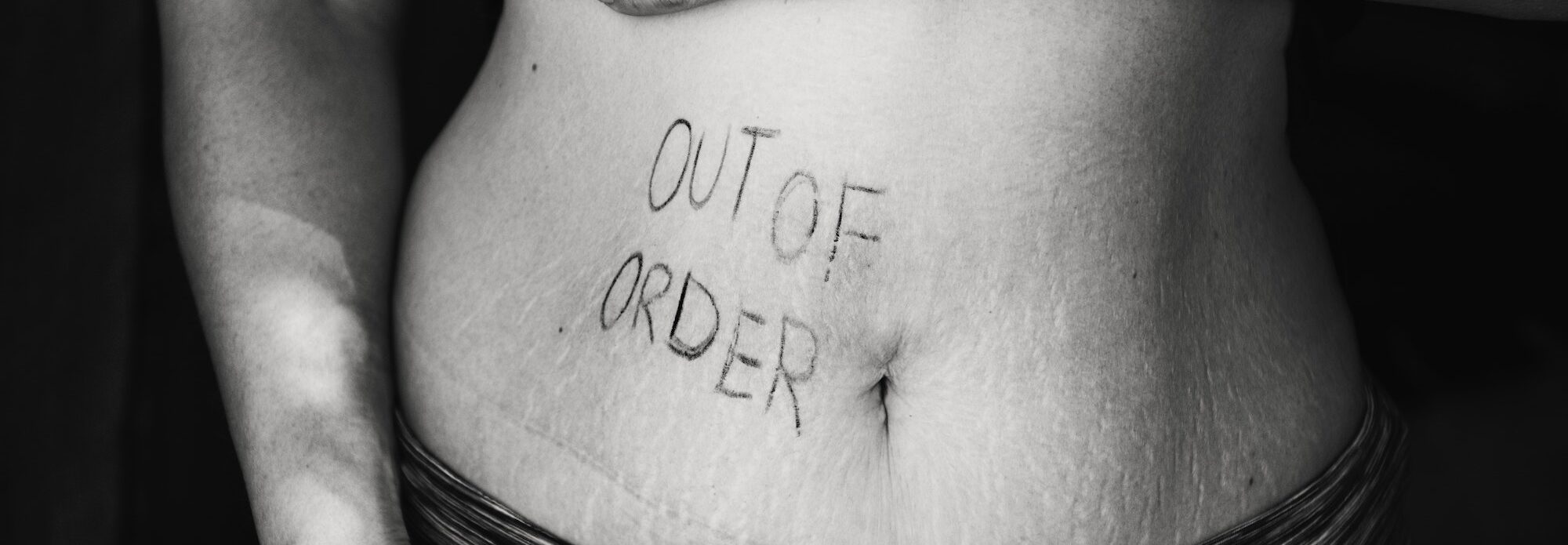 Words "Out of order" on woman's belly